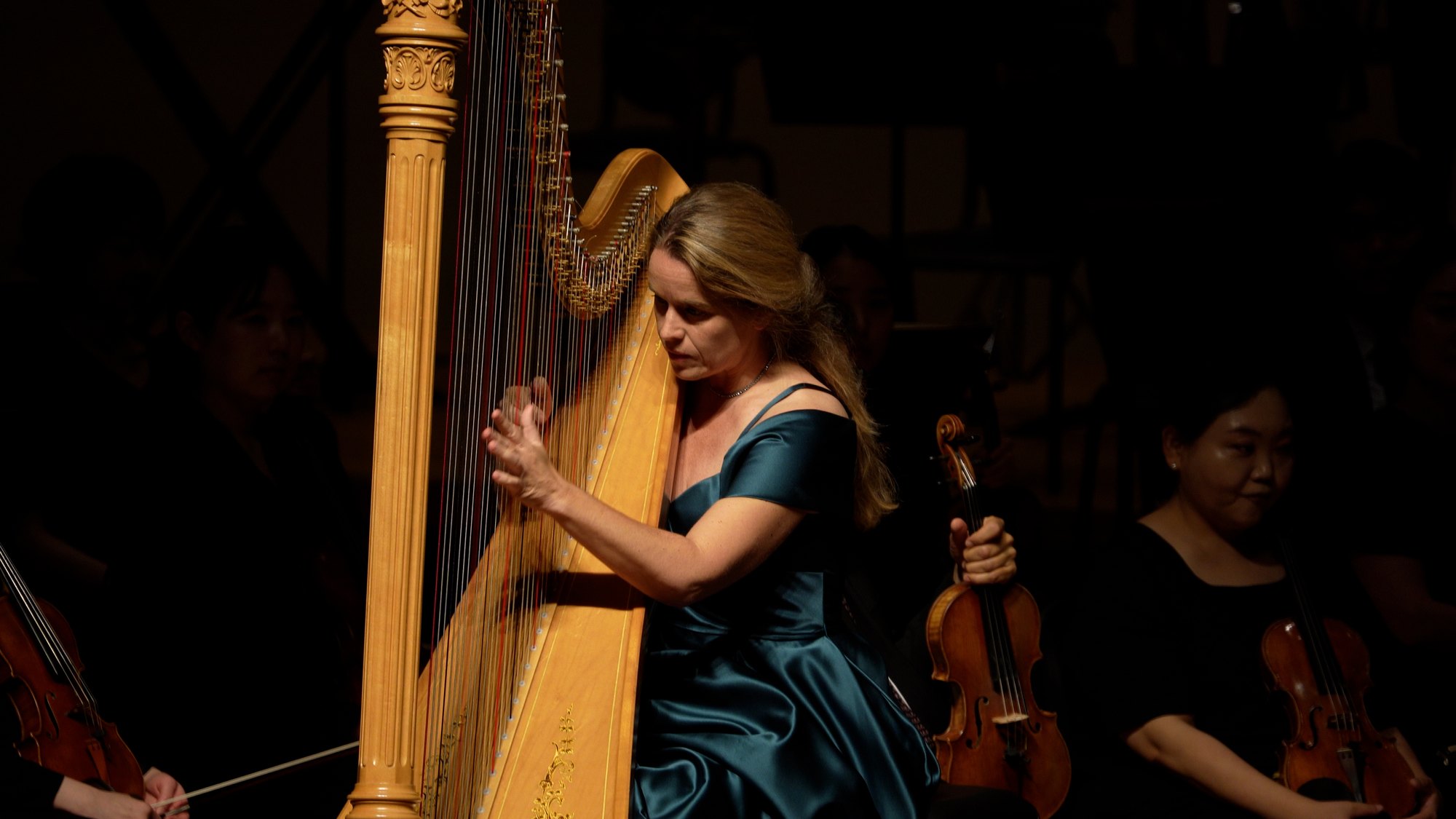 Mirjam Schröder playing the harp with the orchestra
