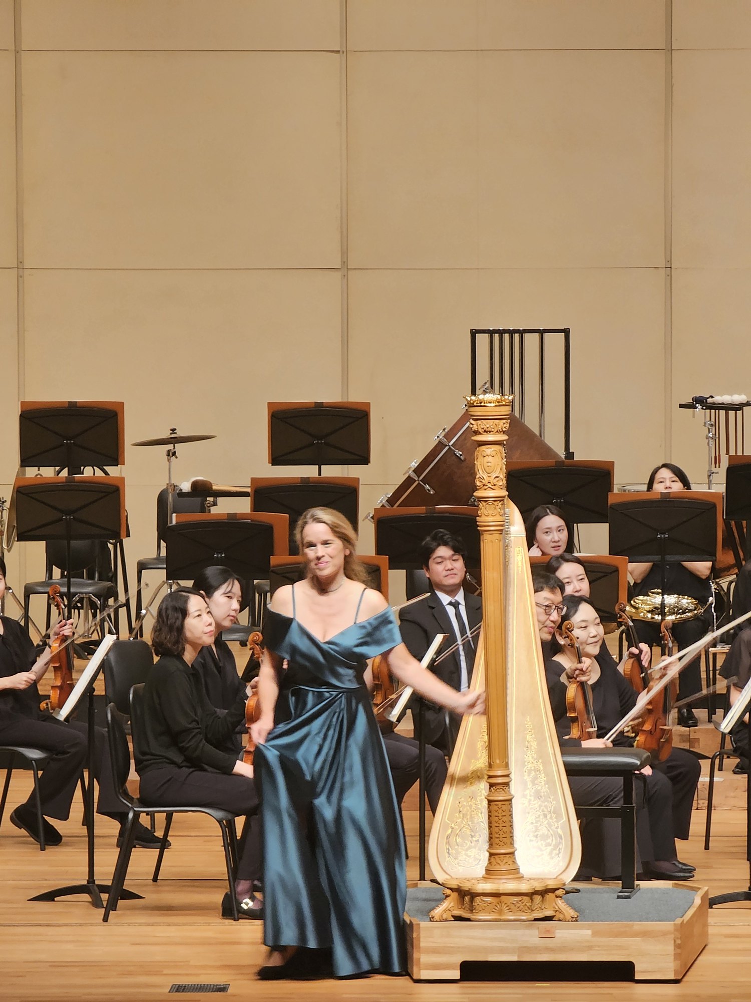 Mirjam Schröder acknowledging the audience beside her harp